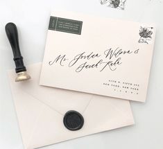 an envelope with a rubber stamp and a wax seal on it next to some flowers