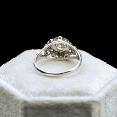 an engagement ring sitting on top of a white box