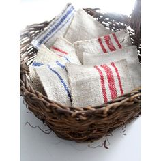 three red, white and blue towels are in a wicker basket on a table