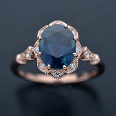 an oval blue sapphire and diamond ring on a black surface with white diamonds around it