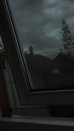 an open window with rain on the outside