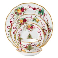 a set of four plates with flowers and ribbons on the rim, each plate has a matching saucer