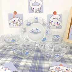 a table topped with plates and bowls filled with cartoon character dishes next to pictures on the wall