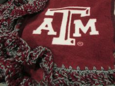 the texas a & m aggies logo is on top of a red and white blanket