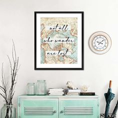 a map with the words not all who wander are lost on it is framed above a green cabinet