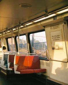 the inside of a train car with red seats and white railings on both sides