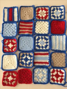 crocheted squares with red, white and blue designs are arranged on a table