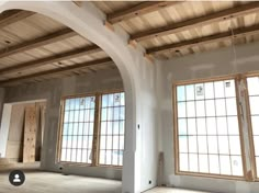 an empty room with three large windows and no one in the room to be used