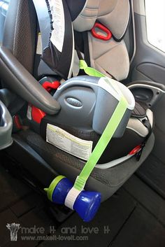 an infant car seat in the back of a vehicle with safety belt around it's neck