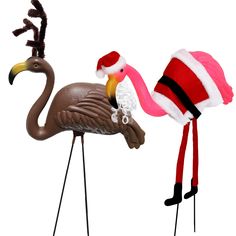 two flamingos wearing christmas hats and standing next to each other