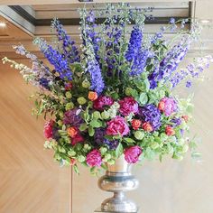 a silver vase filled with lots of colorful flowers