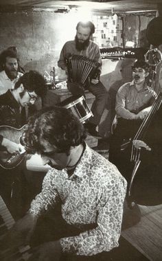 an old black and white photo of people playing instruments