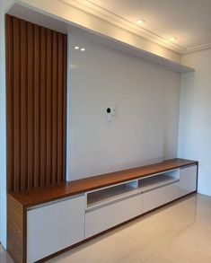 an empty living room with a large entertainment center in the middle and wood paneling on the wall