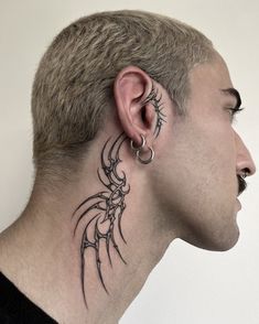 a man with a tattoo on his neck and behind the ear, looking to the side