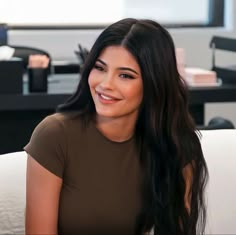 a woman with long black hair sitting down