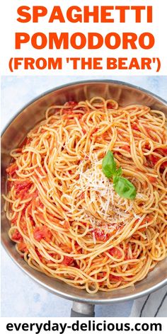 spaghetti with tomato sauce and parmesan cheese in a pan on top of a table