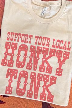 a t - shirt that says support your local honky tonyk on it sitting on a table