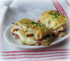 two pieces of pizza sitting on top of a white plate next to a red and white checkered table cloth