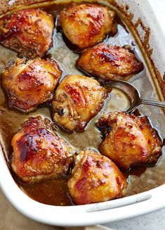 chicken thighs with sauce in a white casserole dish