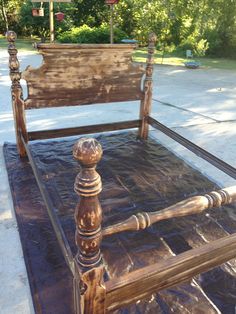 an old wooden bed frame sitting on top of a tarp