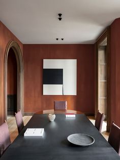 a dining room table with chairs and a plate on the table in front of it