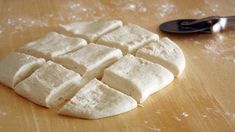 several pieces of tofu sitting on top of a wooden cutting board