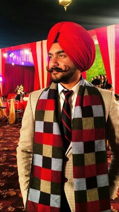 a man wearing a red turban and black tie