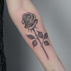 a black and white rose tattoo on the arm