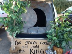 the trunk of a car with plants growing out of it and a sign that says, the grave could not hold the king