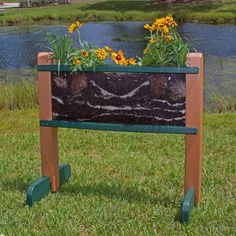 a planter with flowers in it sitting on the grass