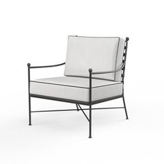 a white chair sitting on top of a white floor next to a black metal frame