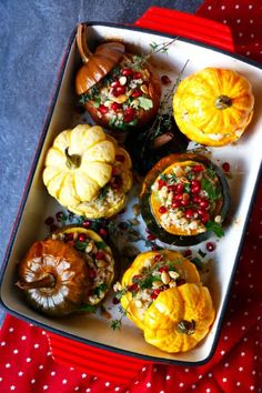 pumpkins and gourds are arranged on a platter with pomegranates