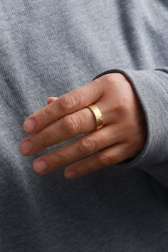 a person wearing a gold ring on their left hand