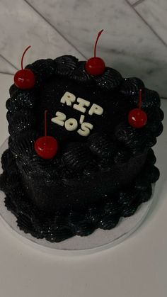 a black cake with red cherries and the words r f p o s on it