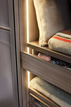 the drawers are open and neatly organized with items in them, such as pillows or blankets