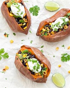 three baked sweet potatoes with black beans, corn and avocado garnish