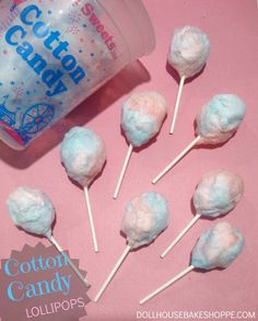 some cotton candy lollipops are on a pink table