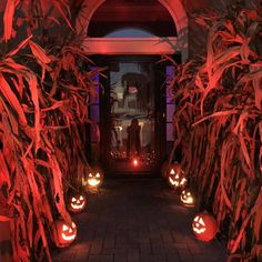 some pumpkins are lit up in front of a door with red lights on them