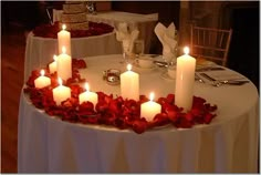 a table topped with lots of candles and roses