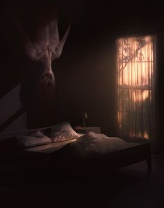 a bed in a dark room next to a window