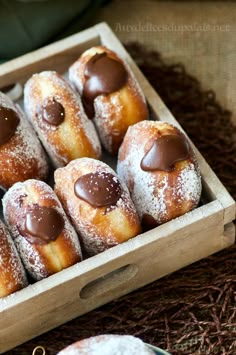 a wooden box filled with chocolate covered donuts