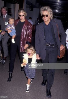 two women and a child are walking through an airport with their mother holding her hand