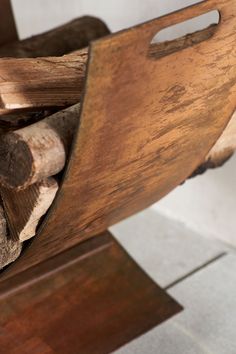 a close up of a wooden chair with logs in it