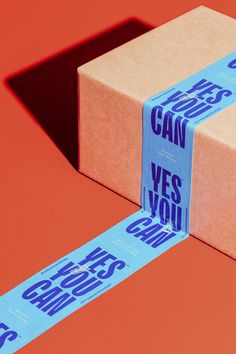 two wrapped presents sitting on top of an orange surface with blue lettering that says can't yes you?