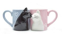 two coffee mugs with cats on them, one has a heart and the other has a cat's head