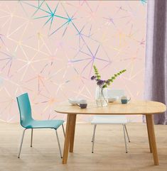 two chairs and a table in front of a pink wall with colorful stars on it