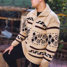 a man wearing a sweater and black leggings standing in front of a building