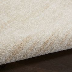 a close up view of a white rug on a wooden floor