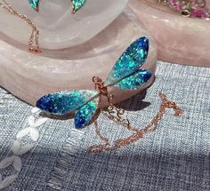 ❤️100% Handmade Copper Wire & UV epoxy Ocean Ombre Dragonfly Pendant Necklace and earrings!  This is a 100% Handmade Dragonfly pendant necklace and earrings were designed and made by me, Elle!  I make these Dragonflies using pure copper wire which I hand shape into each wing, even adding the veins within the wing depending on the colors chosen. After the Dragonfly sections are made I fill them with UV epoxy, adding natural Mica powder to change the colors.  The necklace pendant is about 3" wide Adjustable Wing-shaped Jewelry For Gifts, Adjustable Wing-shaped Jewelry Gift, Handmade Wing-shaped Jewelry For Party, Iridescent Butterfly-shaped Handmade Jewelry, Handmade Iridescent Butterfly Jewelry, Handmade Iridescent Jewelry In Butterfly Shape, Iridescent Fairy Jewelry For Parties, Iridescent Fairy-style Jewelry For Parties, Blue Fairy Jewelry For Party