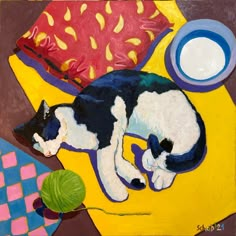 a painting of a black and white cat sleeping on a yellow blanket next to a green ball of yarn